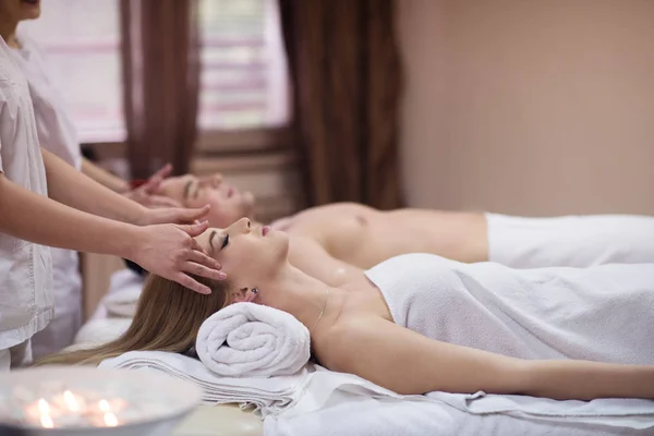 Casal desfrutando de massagem na cabeça no spa — Fotografia de Stock