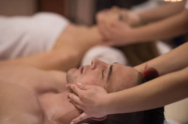 Casal desfrutando de massagem na cabeça no spa — Fotografia de Stock