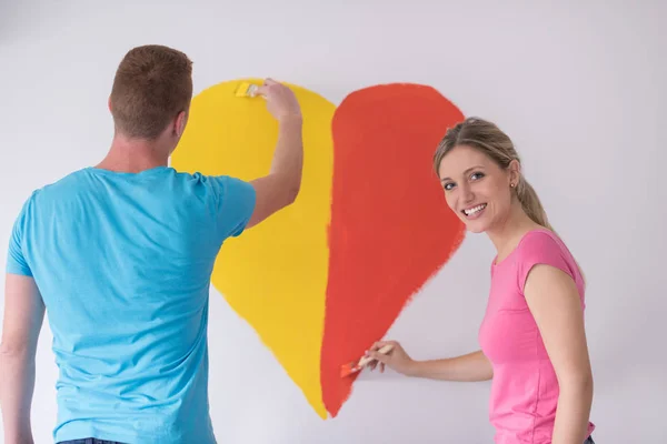 Couple painting heart on wall — Stock Photo, Image