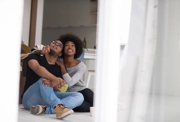 Pareja afroamericana relajándose en casa nueva —  Fotos de Stock