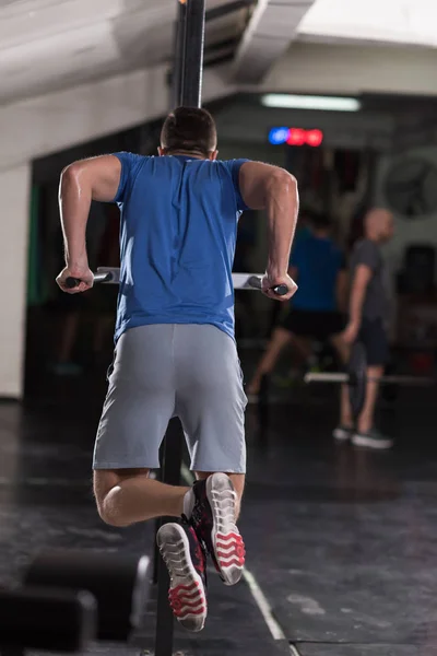 Hombre haciendo ejercicios barras paralelas —  Fotos de Stock
