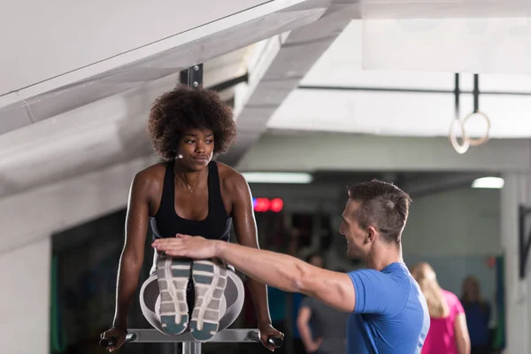 Svart kvinna gör Barr träning med tränare — Stockfoto