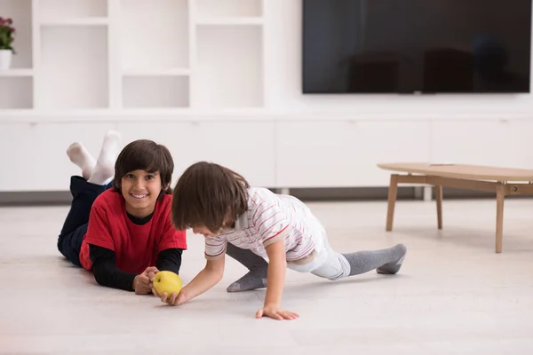 Boys having fun with an apple on the floor — Stock Photo, Image