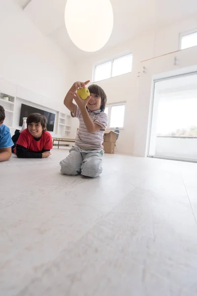 Boys having fun with an apple on the floor — Stock Photo, Image