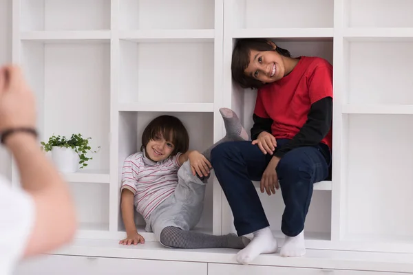 Giovani ragazzi in posa su uno scaffale — Foto Stock