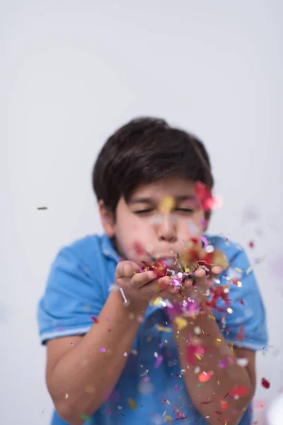 Niño soplando confeti — Foto de Stock