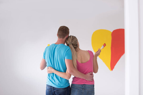 couple painting heart on wall