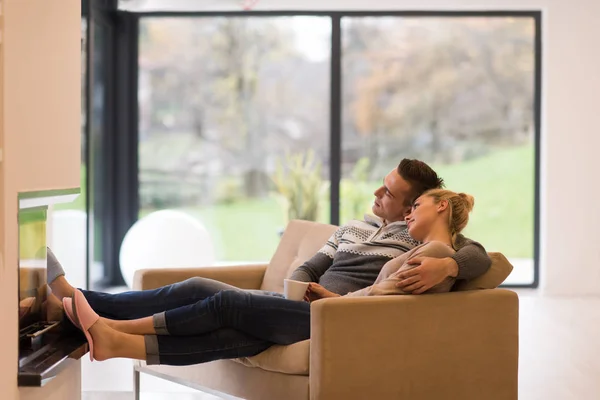 Young romantic couple sitting on sofa — Stock Photo, Image