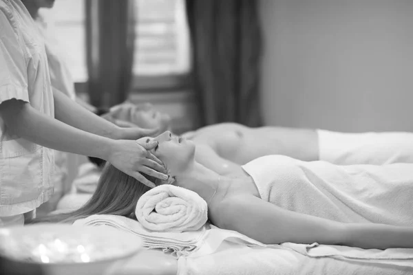Couple enjoying head massage at spa — Stock Photo, Image