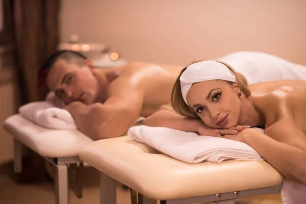 Ungt par ligga på massagebänk — Stockfoto