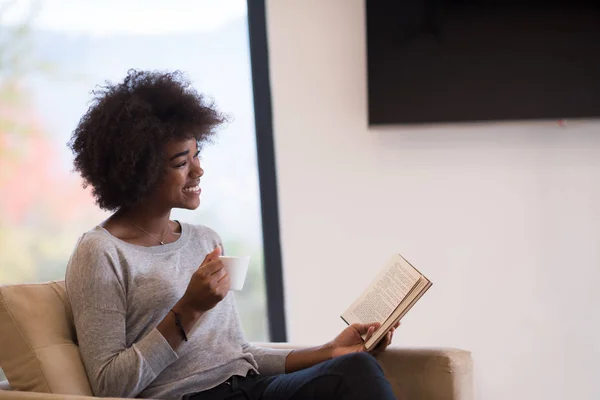 Γυναίκα πίνοντας καφέ και διαβάζοντας βιβλίο — Φωτογραφία Αρχείου
