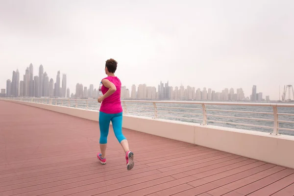 Mujer corriendo en el paseo marítimo — Foto de Stock