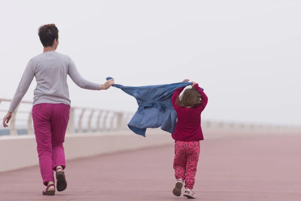 Мама и милая маленькая девочка на набережной у моря — стоковое фото
