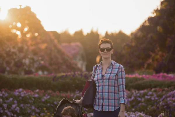 Mor och dotter i blomsterträdgård — Stockfoto