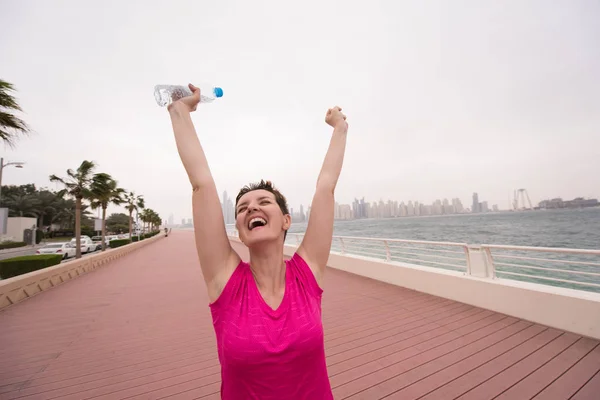Νεαρή γυναίκα γιορτάζει την επιτυχή κατάρτιση τρέξιμο — Φωτογραφία Αρχείου