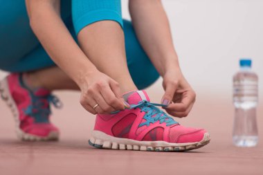 genç kadın üzerinde spor ayakkabı ayakkabı bağcığı bağlama