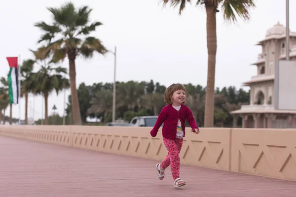 Cute little girl on the promenade by the sea — Stock Photo, Image
