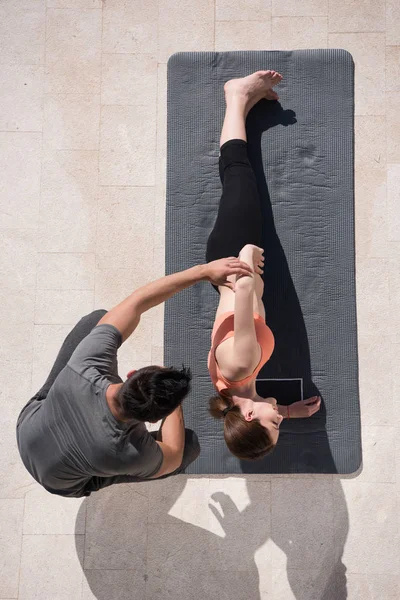 Mujer con entrenador personal haciendo ejercicios de yoga por la mañana top vie — Foto de Stock