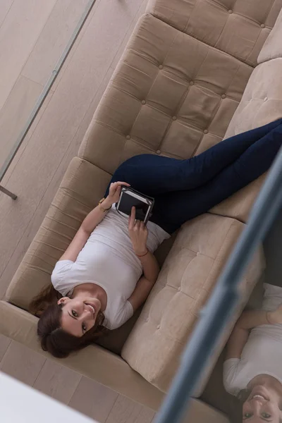 タブレットコンピュータでソファの上の女性 — ストック写真