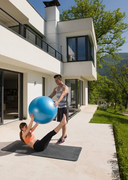 Vrouw en persoonlijke trainer doen oefening met pilates bal — Stockfoto