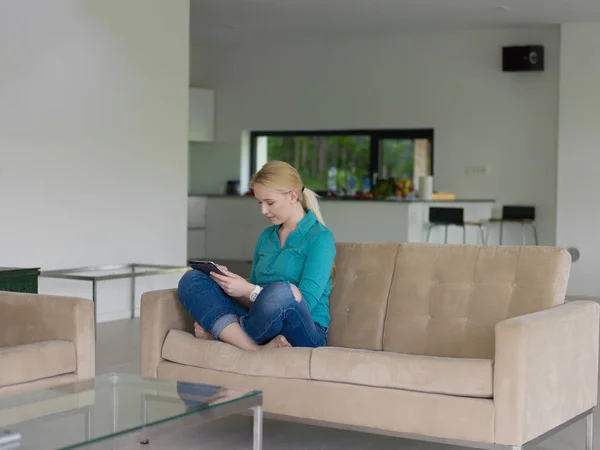 Kvinna på soffan med hjälp av surfplatta dator — Stockfoto