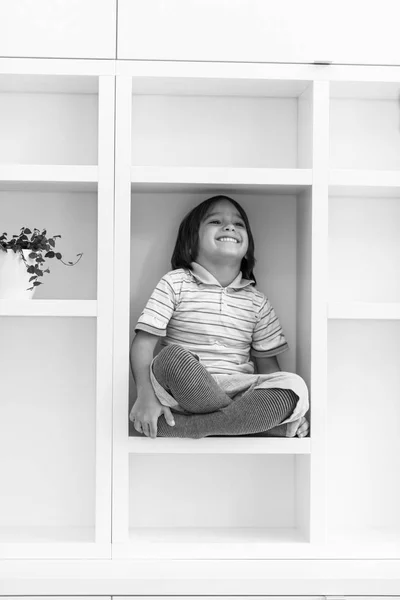 Menino posando em uma prateleira — Fotografia de Stock