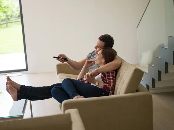 Fiatal pár a kanapén tévézik — Stock Fotó