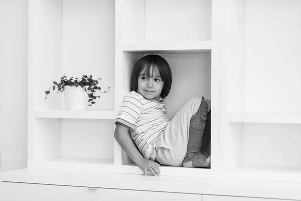 Giovane ragazzo posa su uno scaffale — Foto Stock