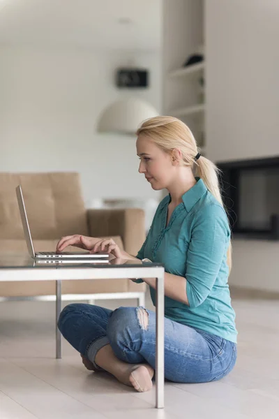 Genç kadın yerde dizüstü bilgisayar kullanan — Stok fotoğraf