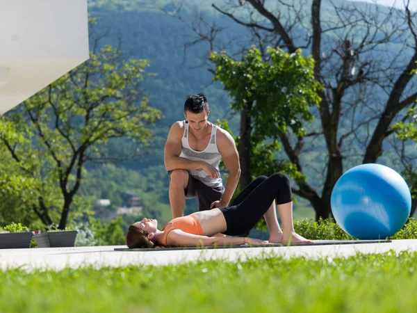 Mulher com personal trainer fazendo exercícios de ioga matinal — Fotografia de Stock
