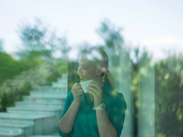 Mladá žena pít ráno kávu u okna — Stock fotografie