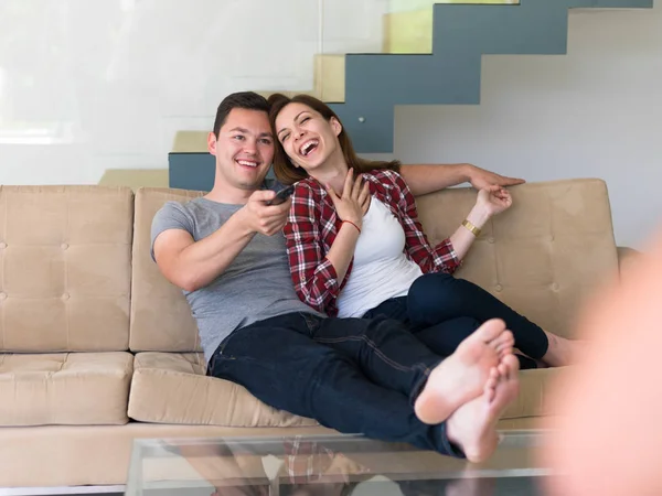 Jovem casal no sofá assistindo televisão — Fotografia de Stock