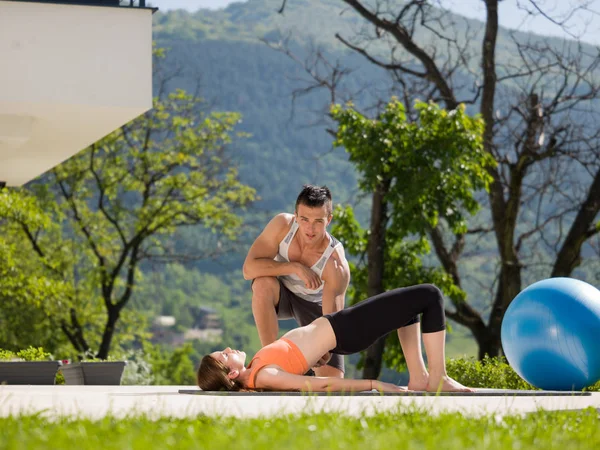 Kobieta z osobistym trenerem robi poranne zajęcia jogi ćwiczenia — Zdjęcie stockowe