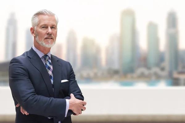 Hombre de negocios sénior frente a la gran ciudad — Foto de Stock