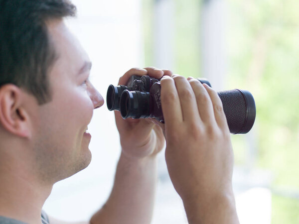 man looking with binoculars