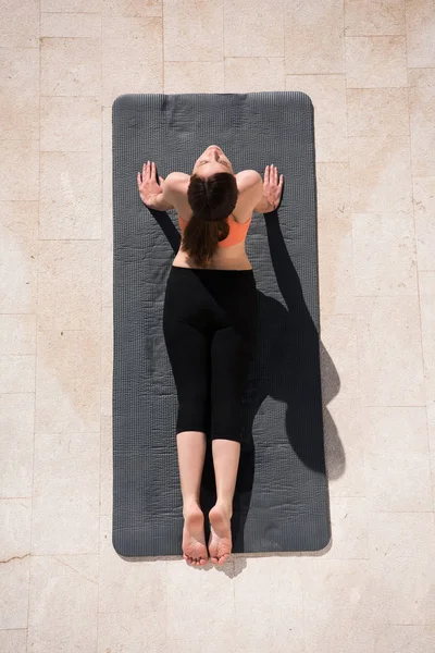 Vrouw doet ochtend yoga oefeningen bovenaanzicht — Stockfoto