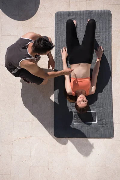 Mujer con entrenador personal haciendo ejercicios de yoga por la mañana top vie — Foto de Stock