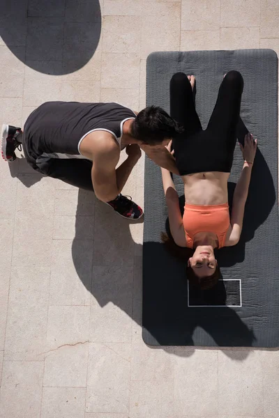 Mujer con entrenador personal haciendo ejercicios de yoga por la mañana top vie — Foto de Stock