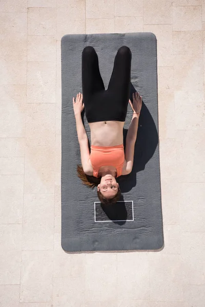 Mujer haciendo ejercicios de yoga por la mañana vista superior — Foto de Stock