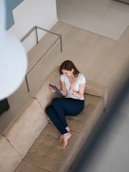 Mujer en el sofá usando tableta — Foto de Stock