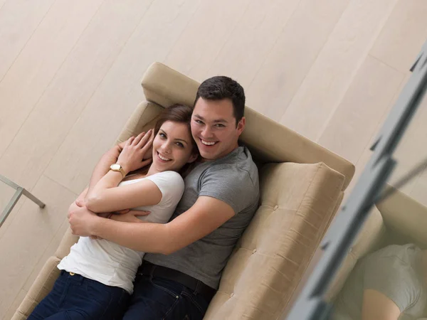 Jovem casal bonito abraçando no sofá — Fotografia de Stock