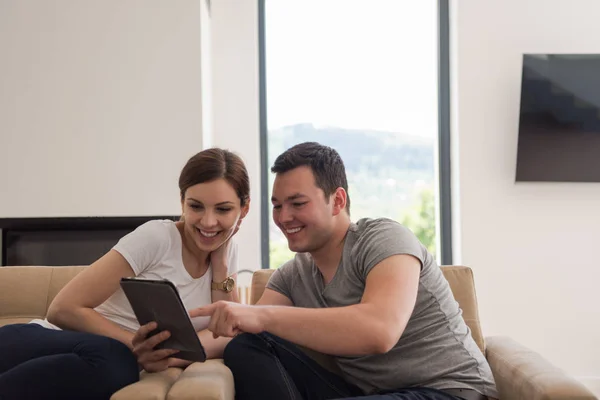 Par koppla av hemma med tablet-datorer — Stockfoto