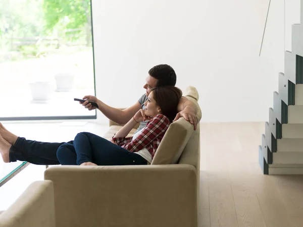 Fiatal pár a kanapén tévézik — Stock Fotó