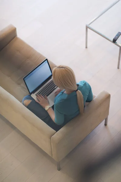 Ung kvinna som använder laptop hemma — Stockfoto