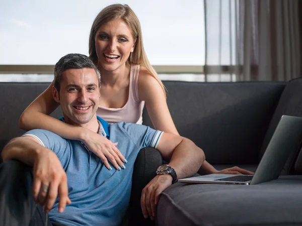 Attraktivt par använder en Laptop på soffan — Stockfoto