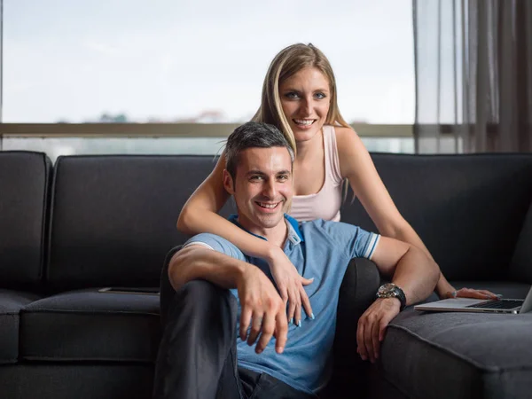 Attraktivt par använder en Laptop på soffan — Stockfoto