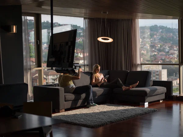 使用技术在现代公寓的沙发上的女人 — 图库照片