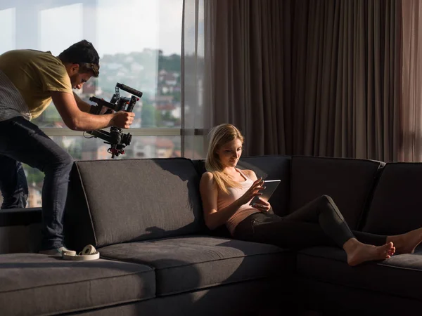 使用技术在现代公寓的沙发上的女人 — 图库照片