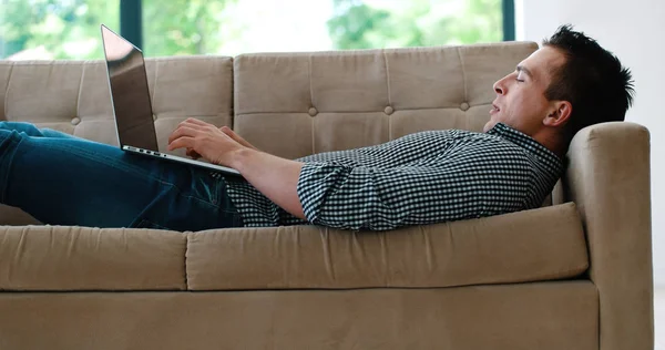 Hombre usando el portátil en la sala de estar — Foto de Stock