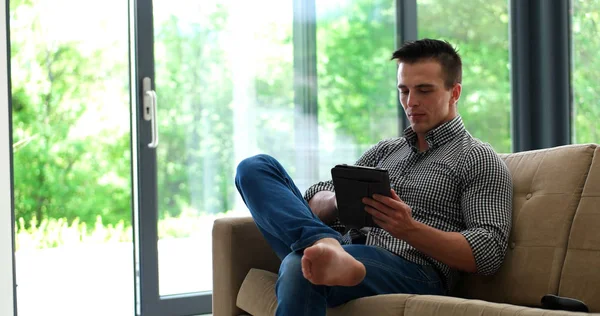 Mann Entspannt Sich Auf Couch Luxusvilla Und Nutzt Tablet — Stockfoto